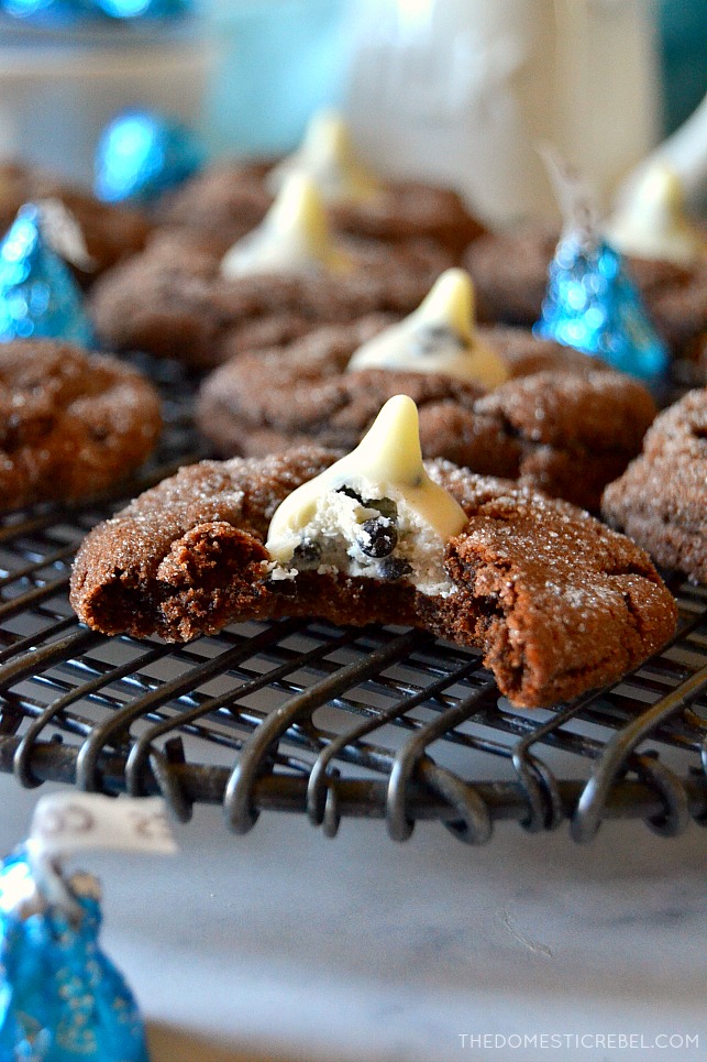Chocolate cookies & cream cookie with bite missing on a wire rack